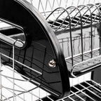 Close-up view of a 2-tier dish rack showing the glossy black side frame connected to chrome wire shelves with a metal dome nut.