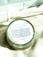 Bottom label of a clear glass abundance ritual candle showing manifestation instructions and a quote by Esther Hicks, placed on a kitchen textile.