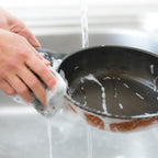 Hand washing the Cheftop nonstick frying pan under running water with soap, demonstrating the easy-clean surface.