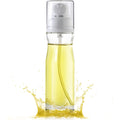 Reusable oil mister spraying fine mist over food to show air fryer cooking use.