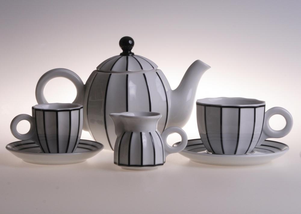 Sarka porcelain coffee and tea set featuring a teapot, milk jug, and two cups with saucers, decorated with black vertical stripes on a white background.