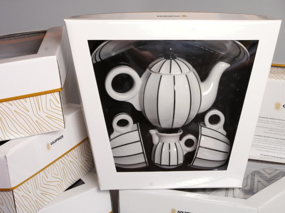 Sarka porcelain coffee and tea set in branded Goldfinger gift packaging, showing the teapot, milk jug, and cups visible through the clear display window.