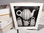 Sarka porcelain coffee and tea set in branded Goldfinger gift packaging, showing the teapot, milk jug, and cups visible through the clear display window.